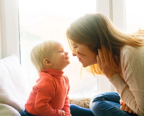 woman and child sitting on fur covered bed 1257099 1