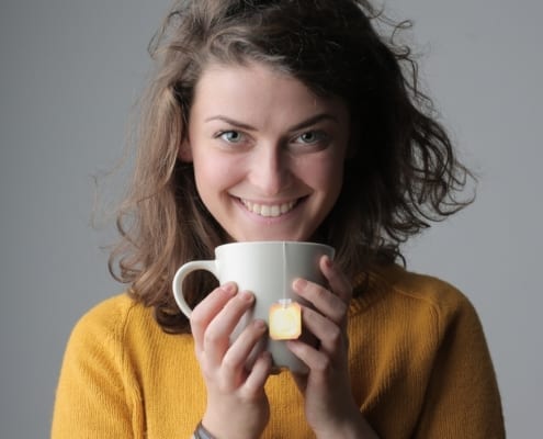 woman in yellow sweater holding white ceramic mug 3981440